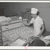 Throwing balls of dough onto rack where they will be shaped into loaves, allowed to rise, and then baked. Bakery, San Angelo, Texas