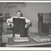 Removing rolls from tray at bakery. San Angelo, Texas