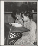 Two Negro children sitting at desk in school. Child in foreground is daughter of Pomp Hall, Negro tenant farmer. Creek County, Oklahoma