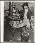 Daughter of Pomp Hall, Negro tenant farmer, taking ashes out of stove before building fire in the morning. Creek County, Oklahoma