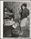 Removing ashes from stove before starting the fire in the early morning. Home of Pomp Hall, Negro tenant farmer. Creek County, Oklahoma