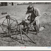 Pomp Hall, Negro tenant farmer, adjusting his cultivator so it will be in readiness for the spring planting. Creek County, Oklahoma