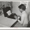 Wife of Pomp Hall, Negro tenant farmer, writing on typewriter. Through union activities this family has developed a desire for higher education. This typewriter is to them a symbol of that education and as such is the most prized family possession