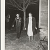 Couple coming around the corner of the house while playing the game, "Fishing for love," at play party in McIntosh County, Oklahoma. See general caption number 26