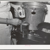 Putting salt in a can in which meat will be canned using the pressure cooker method. This was during the demonstration by a FSA (Farm Security Administration) supervisor at a district meeting of FSA officials. San Angelo, Texas