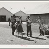 Family group passing a souvenir stand at the San Angelo Fat Stock Show, San Angelo, Texas