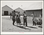 Family group passing a souvenir stand at the San Angelo Fat Stock Show, San Angelo, Texas