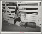 Cattlemen sitting on rolled up camp bed in cattle bed in cattle barns at the San Angelo Fat Stock Show, San Angelo, Texas