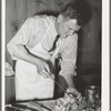 FSA (Farm Security Administration) supervisor sewing up a pork rolled roast during a meat cutting demonstration before a group of FSA supervisors and officials at a district meeting in San Angelo, Texas