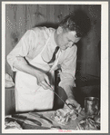 FSA (Farm Security Administration) supervisor sewing up a pork rolled roast during a meat cutting demonstration before a group of FSA supervisors and officials at a district meeting in San Angelo, Texas