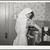 FSA (Farm Security Administration) supervisor demonstrating pressure cooker canning to a group of FSA supervisors and officials at a district meeting at San Angelo, Texas. She is shown packing meat into a can