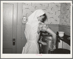 FSA (Farm Security Administration) supervisor demonstrating pressure cooker canning to a group of FSA supervisors and officials at a district meeting at San Angelo, Texas. She is shown packing meat into a can