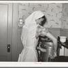 FSA (Farm Security Administration) supervisor demonstrating pressure cooker canning to a group of FSA supervisors and officials at a district meeting at San Angelo, Texas. She is shown packing meat into a can