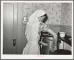 FSA (Farm Security Administration) supervisor demonstrating pressure cooker canning to a group of FSA supervisors and officials at a district meeting at San Angelo, Texas. She is shown packing meat into a can