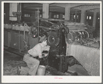Workman cleaning wool scouring machine. San Marcos, Texas