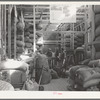 Workers at the Kimble Wool and Mohair Company warehouse standing around the scale and checking desk. Junction, Texas