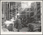 Workers at the Kimble Wool and Mohair Company warehouse standing around the scale and checking desk. Junction, Texas