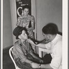 Doctor at clinic examining son of agricultural worker. Agua Fria migratory camp. Arizona