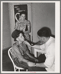 Doctor at clinic examining son of agricultural worker. Agua Fria migratory camp. Arizona