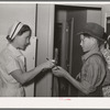 Nurse giving instructions to son of migratory laborer as to how to take medicine. Agua Fria migratory labor camp, Arizona