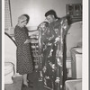 Member of the United Producers and Consumers Cooperative looking at a shower curtain displayed by salesman in the household equipment department. Phoenix, Arizona