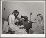 Wife of migratory agricultural laborer sewing at the Aqua Fria migratory labor camp, Arizona. These machines are rented for a nominal sum which remains in the camp fund to be used as the camp committee decides