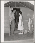 Nurse making a call at one of the individual metal shelters at the Agua Fria migratory labor camp. Arizona