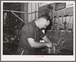 Member of the service department of the United Producers and Consumers Cooperative winding an armature. He was sent by the cooperative to Chicago to learn his trade