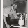 Member filling gallon bottles of milk at the dairy of the Arizona part-time farms. Maricopa County, Arizona