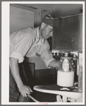 Member filling gallon bottles of milk at the dairy of the Arizona part-time farms. Maricopa County, Arizona