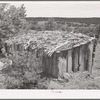 Shed made of slabs and roofed with slabs, dirt and bark strips. Pie Town, New Mexico