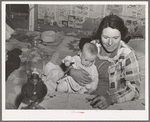 Mrs. Holley holding her baby while playing forty-two at party after literary society meeting. Pie Town, New Mexico. Mrs. Holley and her husband farmed in Texas before homesteading in Pie Town, New Mexico