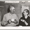 Mr. and Mrs. Besson eating cake and coffee at a Forty-two party at their home. Pie Town, New Mexico. They farmed in Oklahoma near Frederick before homesteading to Pie Town