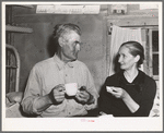 Mr. and Mrs. Besson eating cake and coffee at a Forty-two party at their home. Pie Town, New Mexico. They farmed in Oklahoma near Frederick before homesteading to Pie Town