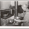 Mrs. George Hutton dishes up sausage made from her own hogs and canned last winter. Pie Town, New Mexico