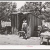 Faro Caudill taking household articles into shed for storage while he moves his dugout. Pie Town, New Mexico
