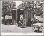 Faro Caudill taking household articles into shed for storage while he moves his dugout. Pie Town, New Mexico