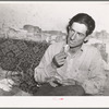 Faro Caudill, homesteader, rolling a cigarette. Pie Town, New Mexico