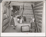 Mrs. Bill Stagg drawing water from her well, which is in enclosed porch in her log house. Pie Town, New Mexico