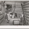 Mrs. Bill Stagg drawing water from her well, which is in enclosed porch in her log house. Pie Town, New Mexico