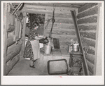 Mrs. Bill Stagg drawing water from her well, which is in enclosed porch in her log house. Pie Town, New Mexico