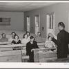 Mr. Whinery, homesteader and licensed preacher, reading the Sunday School lesson in the Farm Bureau building. Pie Town, New Mexico. Mr. Whinery donates his services as a preacher to the church