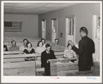 Mr. Whinery, homesteader and licensed preacher, reading the Sunday School lesson in the Farm Bureau building. Pie Town, New Mexico. Mr. Whinery donates his services as a preacher to the church