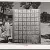 Mrs. Bill Stagg with state quilt she made. Mrs. Stagg helps her husband in the fields with plowing, planting, and weeding corn and harvesting beans, and quilts while she rests during the noon hour. Pie Town, New Mexico