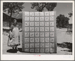 Mrs. Bill Stagg with state quilt she made. Mrs. Stagg helps her husband in the fields with plowing, planting, and weeding corn and harvesting beans, and quilts while she rests during the noon hour. Pie Town, New Mexico