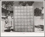 Mrs. Bill Stagg with state quilt she made. Mrs. Stagg helps her husband in the fields with plowing, planting, and weeding corn and harvesting beans, and quilts while she rests during the noon hour. Pie Town, New Mexico