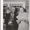 Mr. Besson, president of the literary society holds the lamp for Mrs. Caudill, secretary, during a song at the literary society. Pie Town, New Mexico