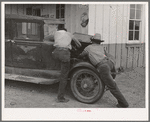 Garage owner and farmer working on a car. Pie Town, New Mexico. The young man who owns the filling station, blacksmith shop, and garage came out from Texas when he could not get work either on the farms or in the farming community towns there