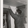 George Hutton, Jr., papering the kitchen for his mother. Pie Town, New Mexico