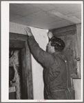 George Hutton, Jr., papering the kitchen for his mother. Pie Town, New Mexico